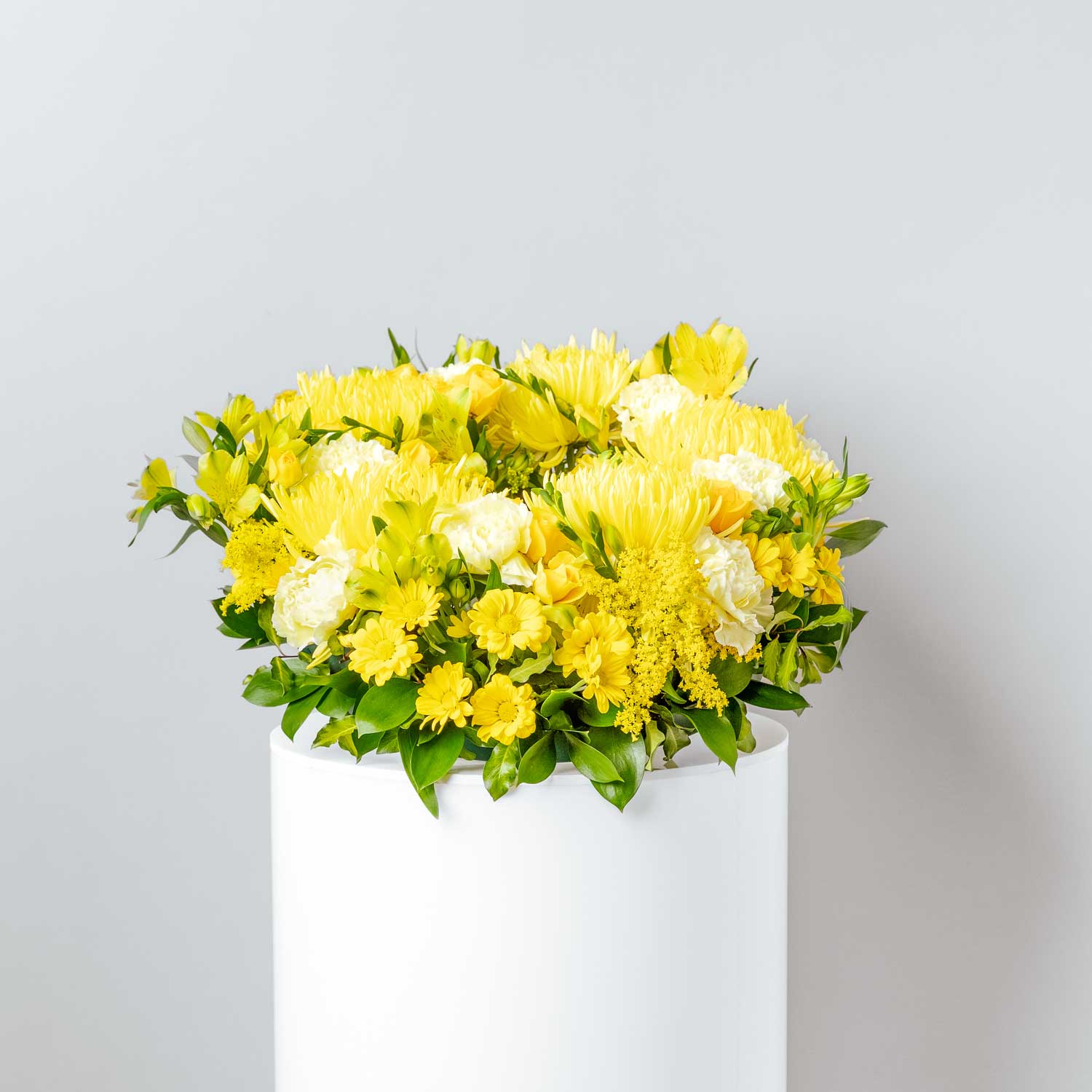 funeral wreath made with bright yellow flowers including roses carnations chrysanthemums freesia golden rod alstromeria created into a circular shape