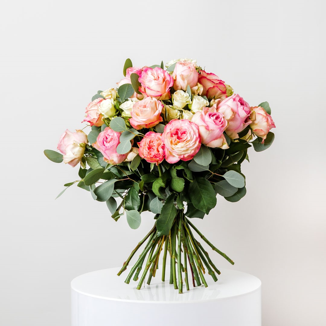a large bouquet of pink and white roses on a base of sage poly gum eucalyptus