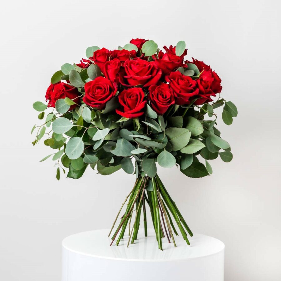 a large bouquet of red roses on a base of poly gum eucalyptus