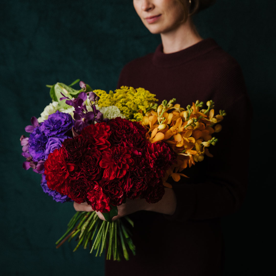 vibrant flowers posy made with red dahlia purple lisianthus green anthirium yellow golden rod and orange orchids