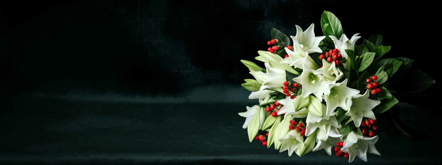 white fragrant christmas lily bouquet arranged with red hypericum berry and lush green foliage