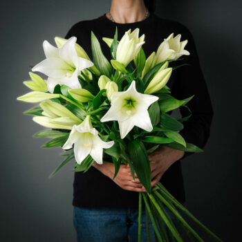 white fragrant long stem christmas lilies arranged into a bouquet