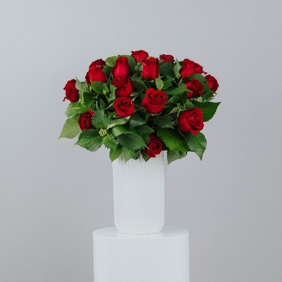 medium size white ceramic cylinder vase filled with red roses and foliage